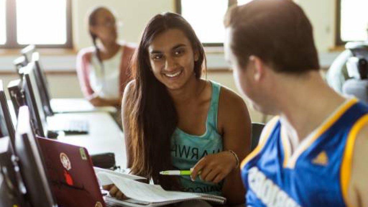 student smiling at another student in a classroom